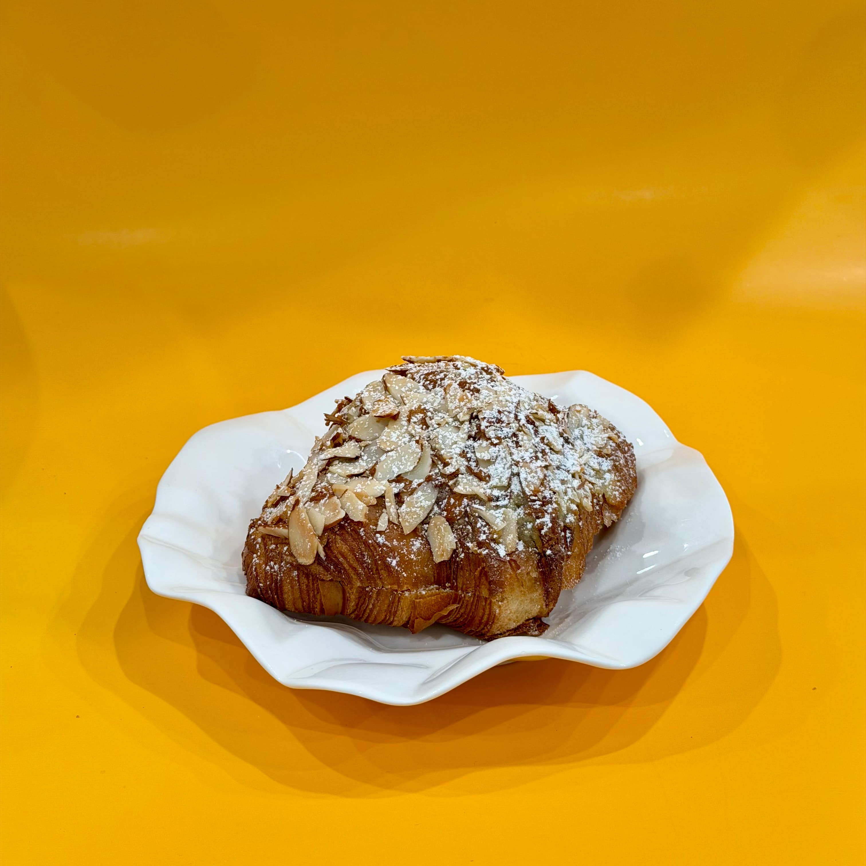 Almond Croissant - Classic twice-baked croissant with almond flakes.